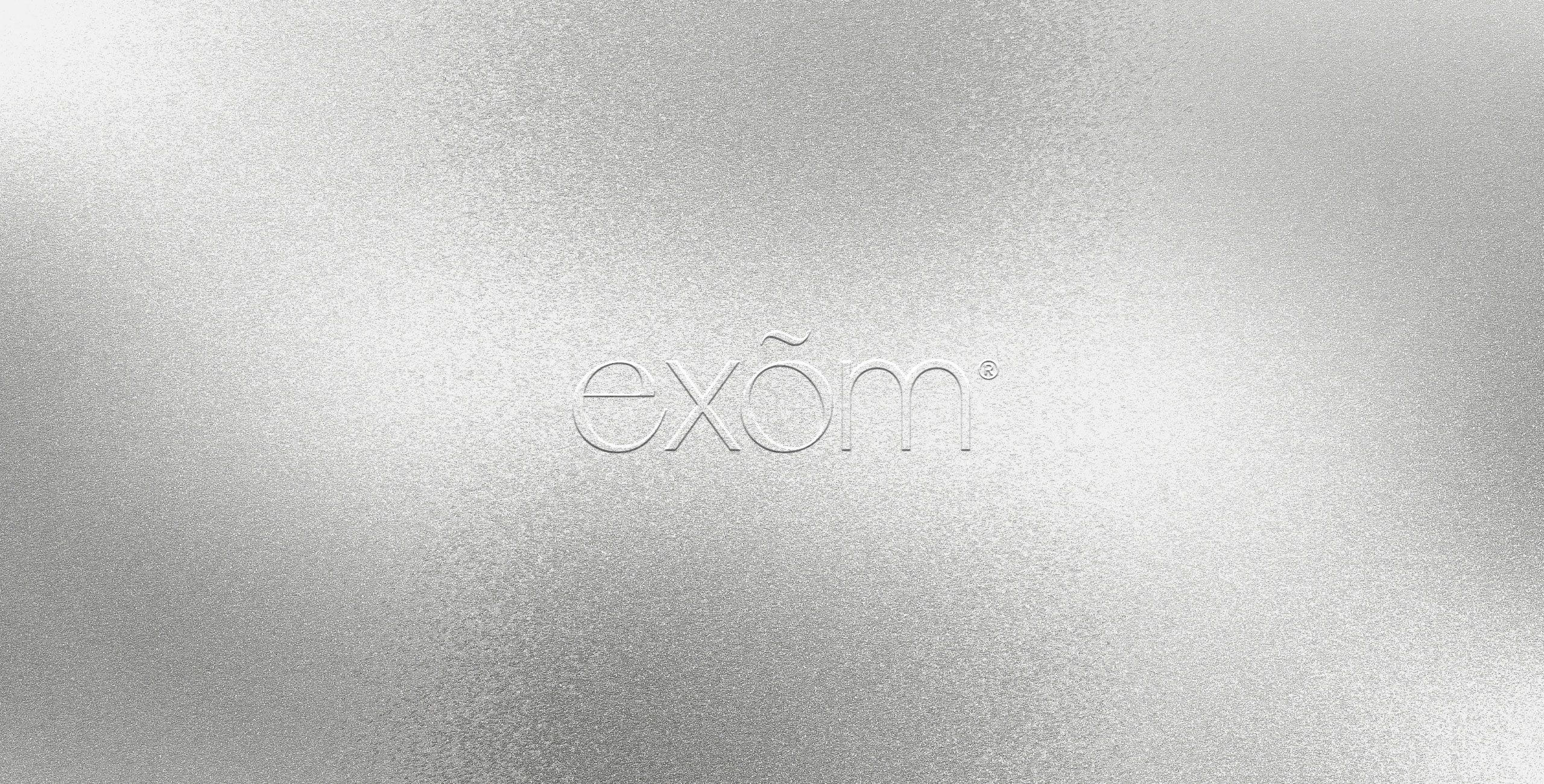 Το λογότυπο exom ανάγλυφο σε ασημί foil - δημιουργικό γραφείο pecora nera design studio